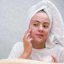 Girl treating her skin, she has red blemishes on her face