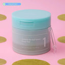 numbuz:n Centella Re-leaf Green Toner Pad jar surrounded by green centella toner pads on a pink background
