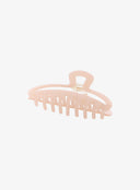 Pink Hair Pin IL530 pink side angle flat lay showing elongated comb teeth row and curved arm with gold spring hinge detail